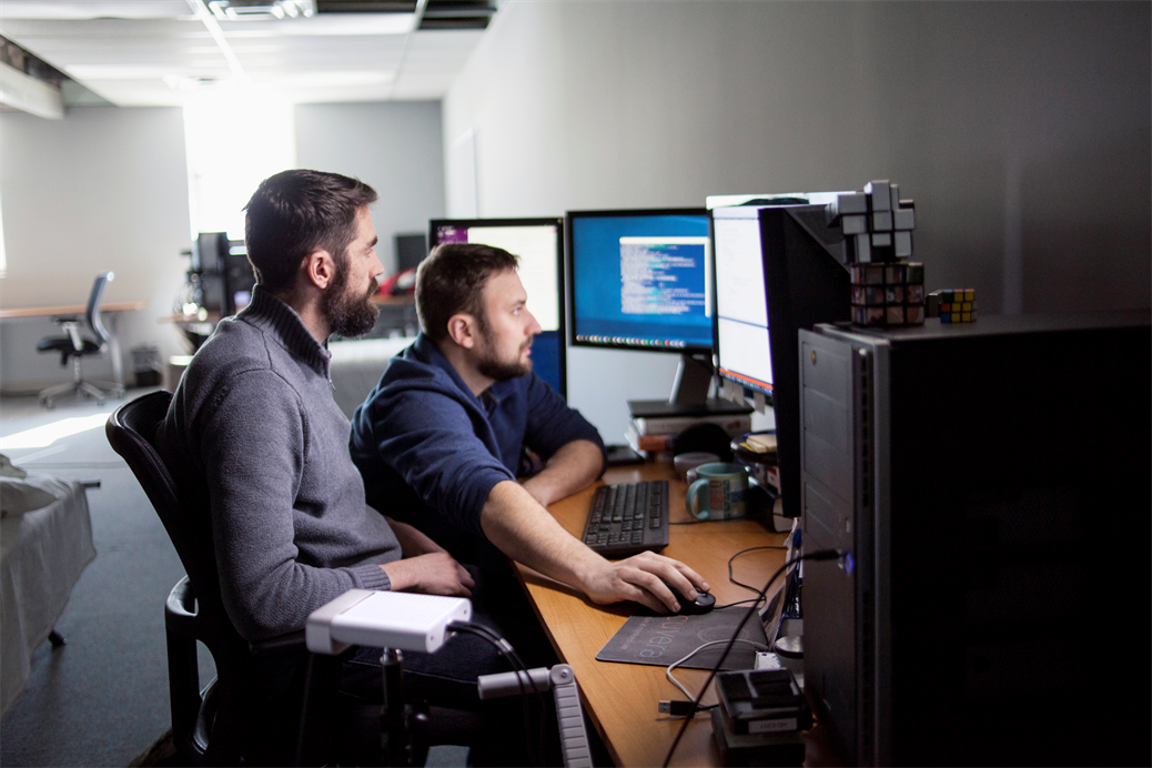 Two software developers using a computer