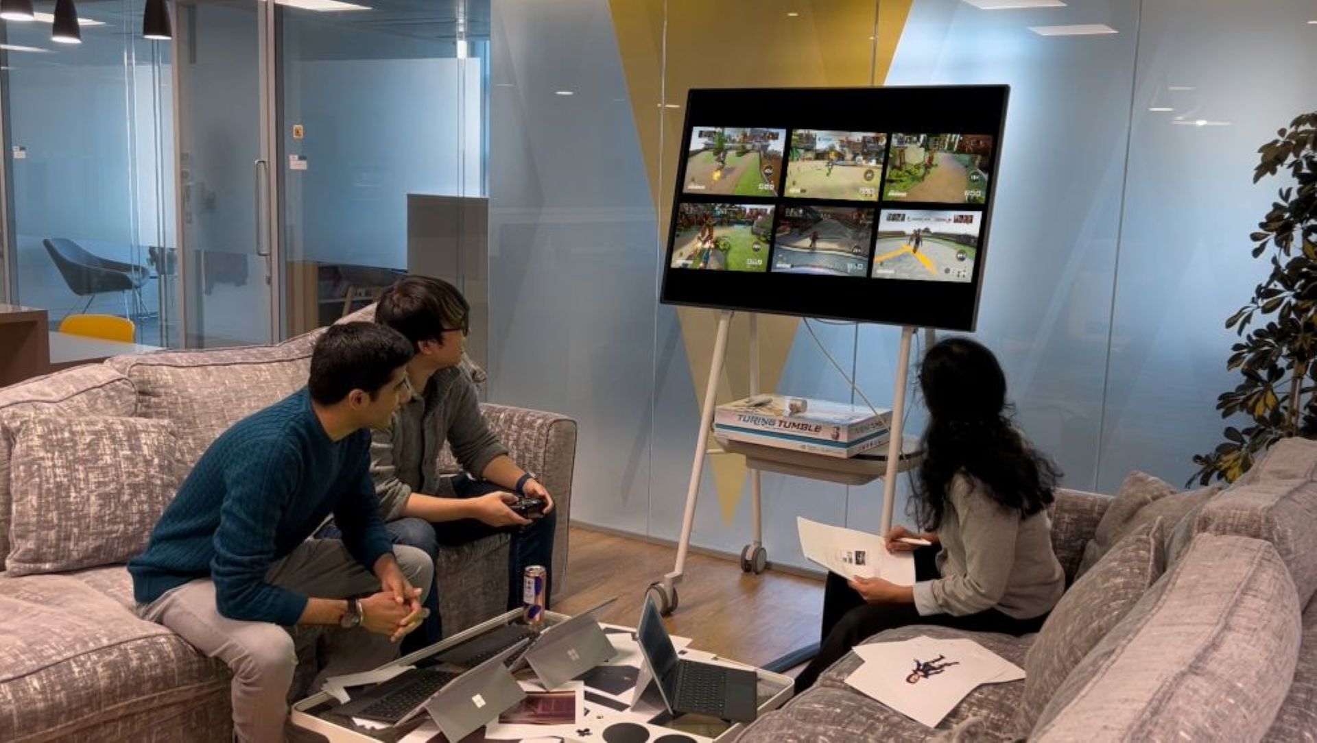 Three people playing a video game on a large screen.