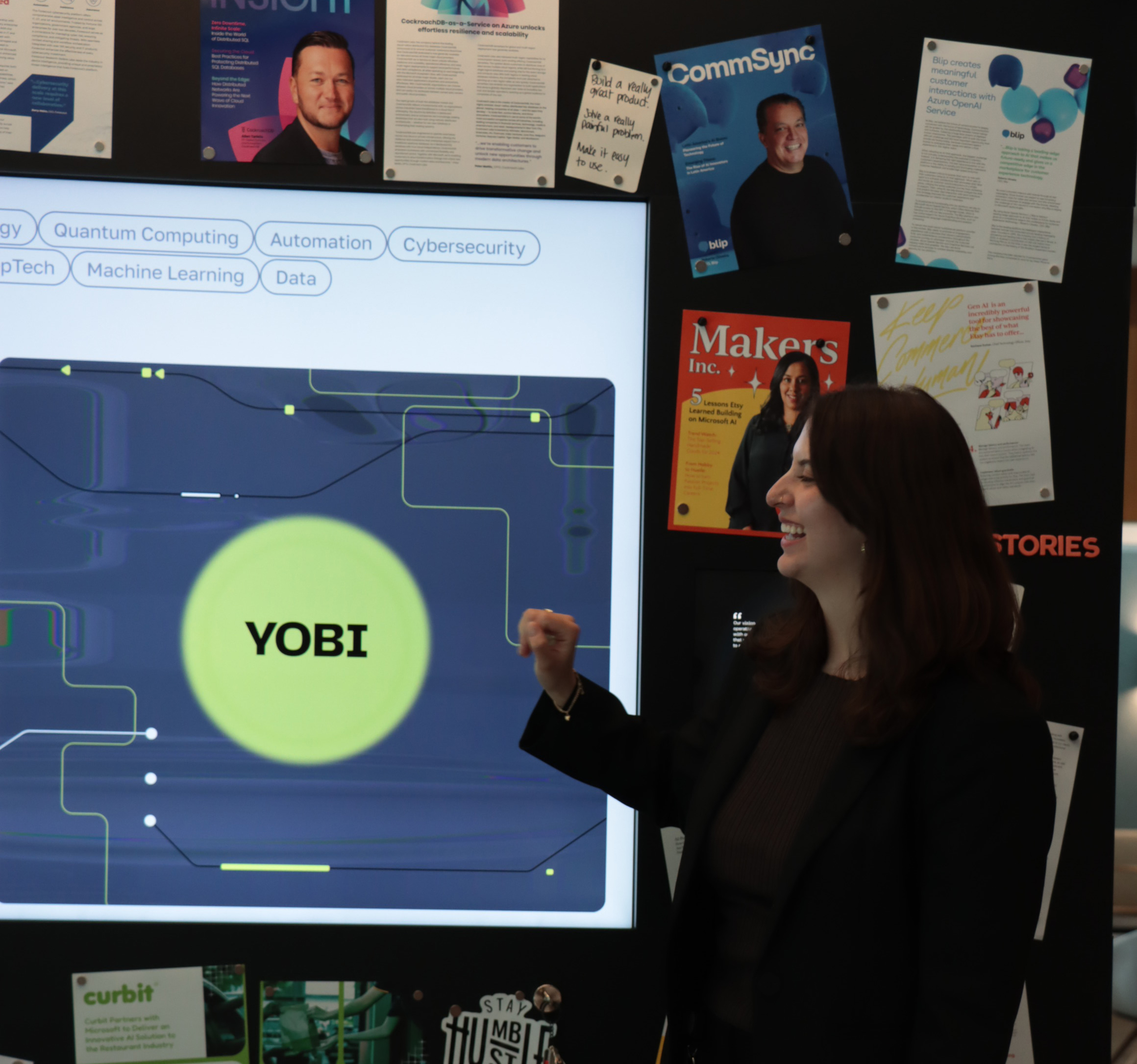 A woman standing in front of a screen that says Yobi.