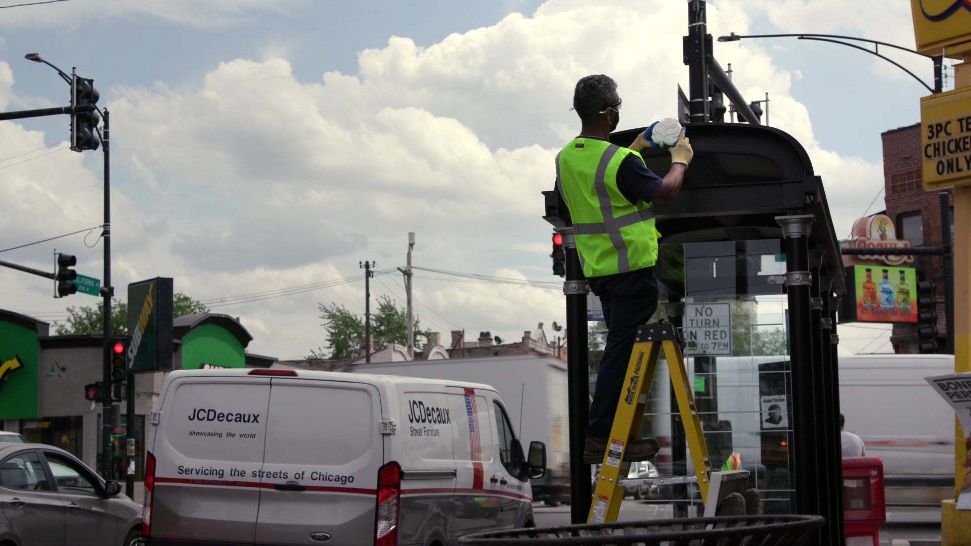 Utility worker installing Project Eclipse device on a bus shelter to monitor air quality.