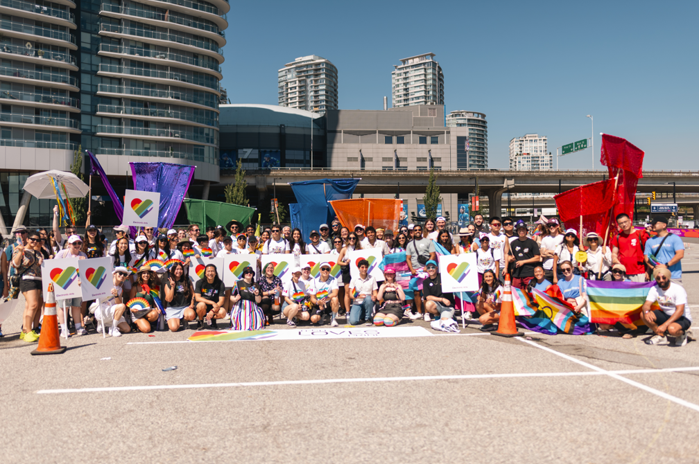 100 Tech Loves Pride marchers pose and cheer together for a celebratory group photo after completing the 2014 Vancouver Pride Parade route.