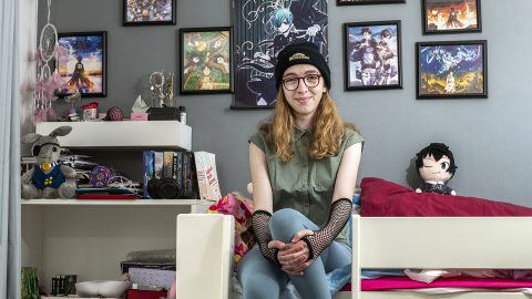 A girl sits on a bed in a room