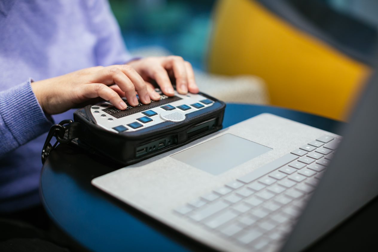 a person uses an accessibility tool with a laptop